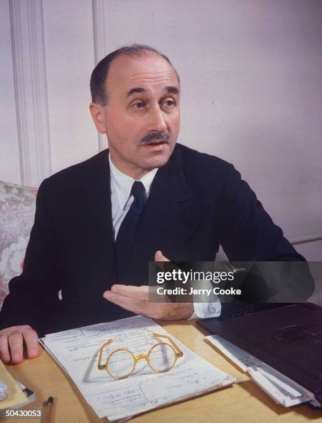 French businessman, banker and later political figure, Jean Monnet sitting in office.