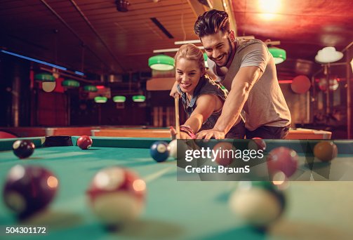 Young happy couple enjoying in a billiard game together. Young happy couple enjoying in a billiard game together.