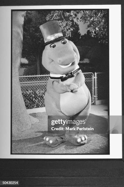 Barney the dinosaur wearing top hat & bow tie, performing song & dance on the TV show Barney And Friends.