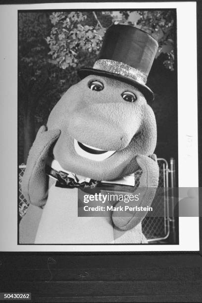 Barney the dinosaur wearing top hat & bow tie, performing song & dance on the TV show Barney And Friends.