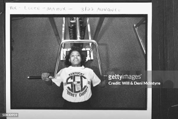Bernadette Locke-Mattox, the asst. Basketball coach at Univ. Of KY, clad in KENTUCKY 1992 SEC BASKETBALL TOURNEY CHAMPS t-shirt as she lies on bench...