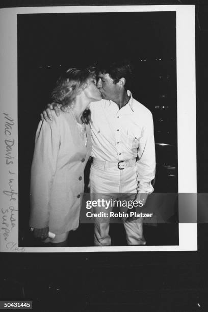 Entertainer Mac Davis kissing wife Lise Gerad as they arrive at the Supper Club for party for Dem. Supporters hosted by TX Gov. Ann Richards during...