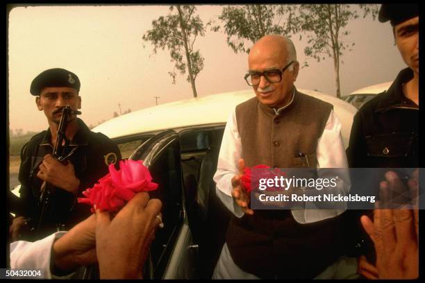 Hindu nationalist BJP member of Parliament/ex-Bharatiya Janata Party pres. L.K. Advani w. Roses fr. Supporters, flanked by bodyguards.