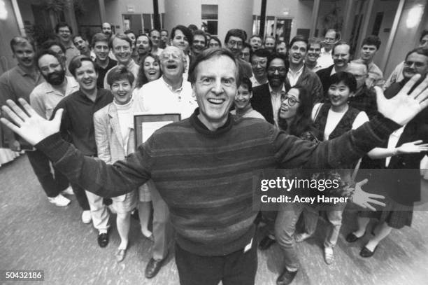 Of Apple Computer John Sculley posing in front of dozens of his happy designers & engineers grouped behind him who were the recipients of plaques &...