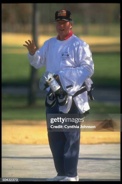 Pres-elect Bill Clinton clad for golf, after game, carrying New Balance running shoes, ready for post-golf jog.