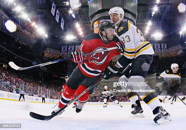 Kyle Palmieri of the New Jersey Devils goes against Zdeno Chara of the Boston Bruins during the first period at the Prudential Center on January 8,...