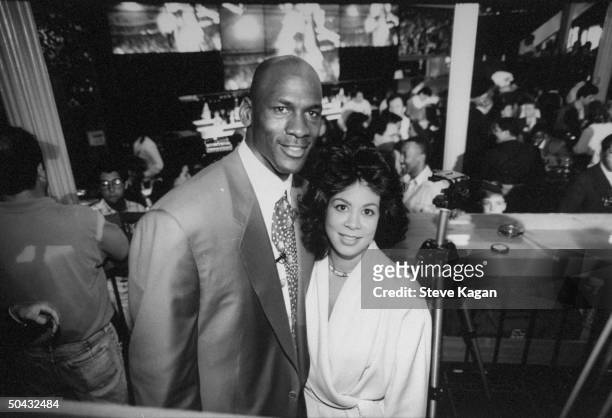 Chicago Bulls basketball star Michael Jordan posing w. Wife Juanita at bar at the opening of his restaurant.