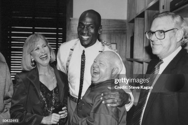 Chicago Bulls basketball star Michael Jordan w. His arm around actor Mickey Rooney while unident. Man & woman look on at the opening of his Michael...