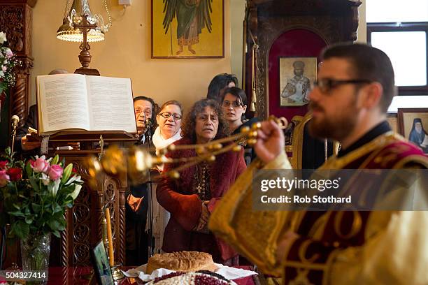 Parishioners and clergy of the Greek Orthodox Church of St Michael the Archangel attend a service for Feast of the Epiphany lead by His Eminence...