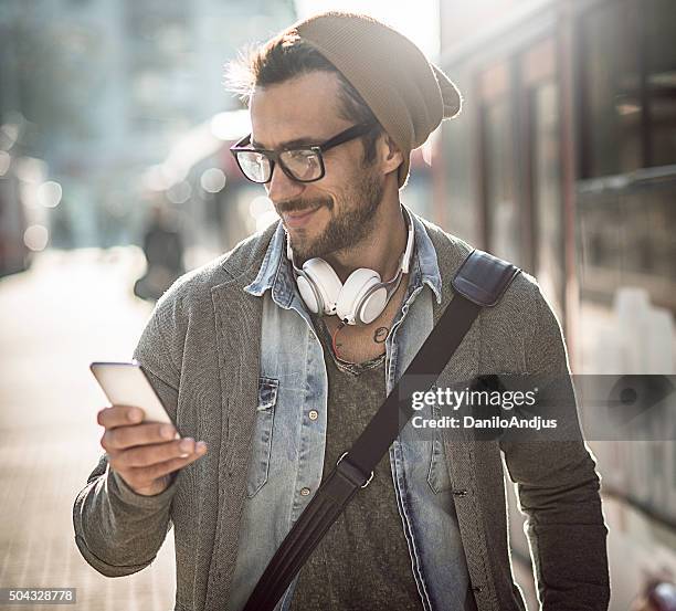 handsome man typing a text message - smirking stock pictures, royalty-free photos & images