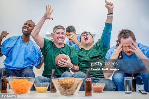 cheering while watching the game - american football tv stock pictures, royalty-free photos & images