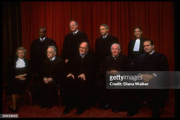 Supreme Court Justices Scalia, Ginsburg, Stevens, Souter, Chief Rehnquist, Kennedy, Blackmun, Thomas & O'Connor sitting for portrait.