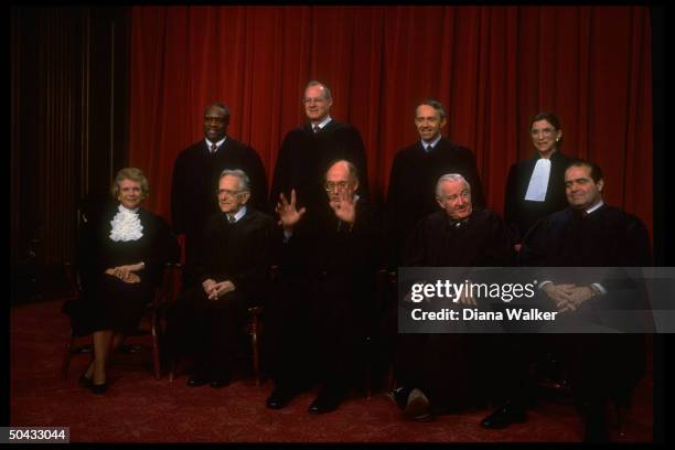 Supreme Court Justices Scalia, Ginsburg, Stevens, Souter, Chief Rehnquist, Kennedy, Blackmun, Thomas & O'Connor sitting for portrait.