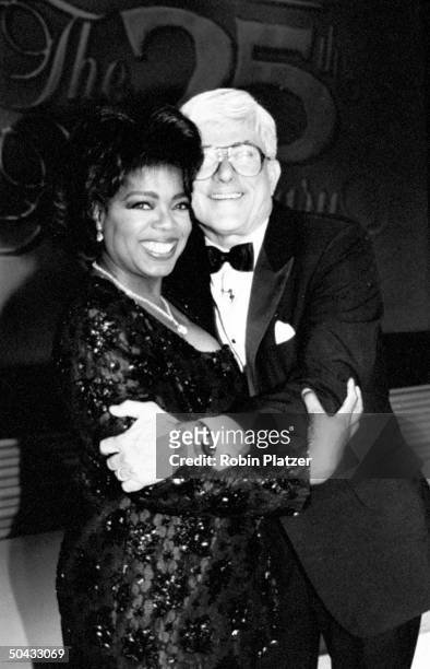 Personality Phil Donahue hugging talk show host Oprah Winfrey at the 25th anniv. Celebration of the Donahue TV show, at the Ed Sullivan Theater.