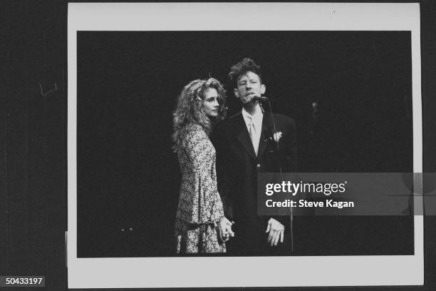 Actress Julia Roberts gazing adoringly at her husband, c/w crooner Lyle Lovett, as he sings into mike during concert at the Deer Creek Music Ctr., on...