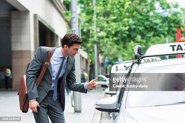 young entrepreneur thanking taxi driver - australia taxi stock pictures, royalty-free photos & images