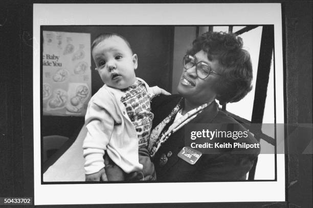 Pres. Clinton's Surgeon Gen. Nominee Dr. Joycelyn Elders, the dir. Of the AR Dept. Of Public Health, holding infant boy at the Central HS Wellness...