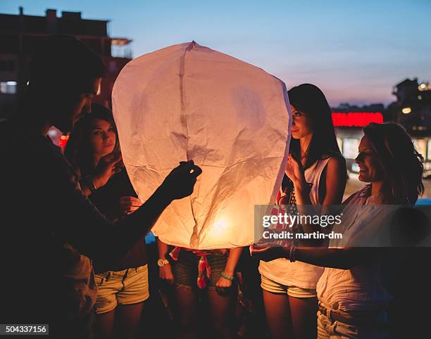 friends releasing paper lantern - papieren lampion stockfoto's en -beelden