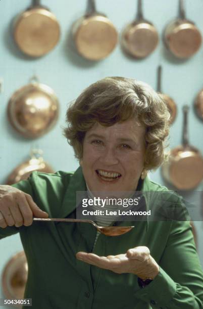 Chef Julia Child posing w. Spoon about to sample broth.