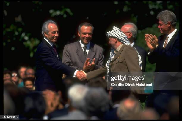 Chmn. Arafat shaking hands w. Israeli For. Min. Peres w. Pres. Clinton, PM Rabin & Russia's Kozyrev, at WH Israel/PLO peace accord signing.