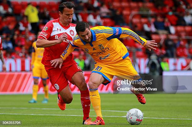 Aaron Galindo of Toluca struggles for the ball with Andre Pierre Gignac of Tigres during the 1st round match between Toluca and Tigres UANL as part...