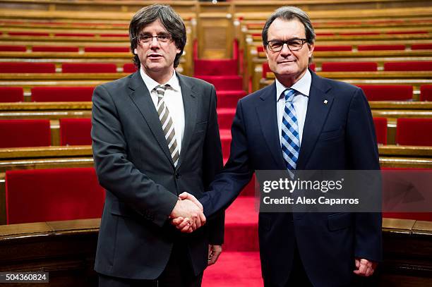 New President of Catalonia Carles Puigdemont shakes hands with former President of Catalonia Artur Mas after being elected as the new President of...