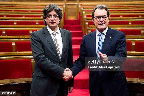 New President of Catalonia Carles Puigdemont shakes hands with former President of Catalonia Artur Mas after being elected as the new President of...