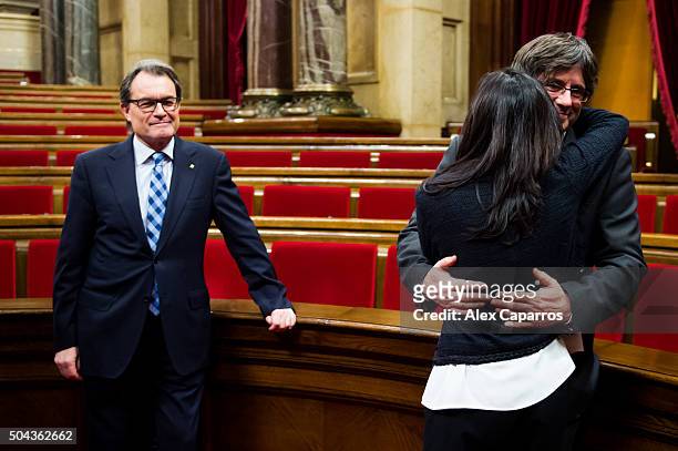 Former President of Catalonia Artur Mas looks on as the new President of Catalonia Carles Puigdemont embraces his wife Marcela Topor after the...