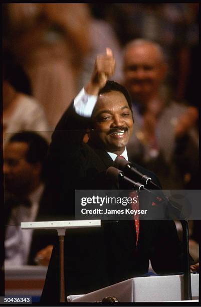 Enthused Rev. Jesse Jackson giving thumbs-up, addressing Democratic Natl. Convention as contender for presidential nomination.