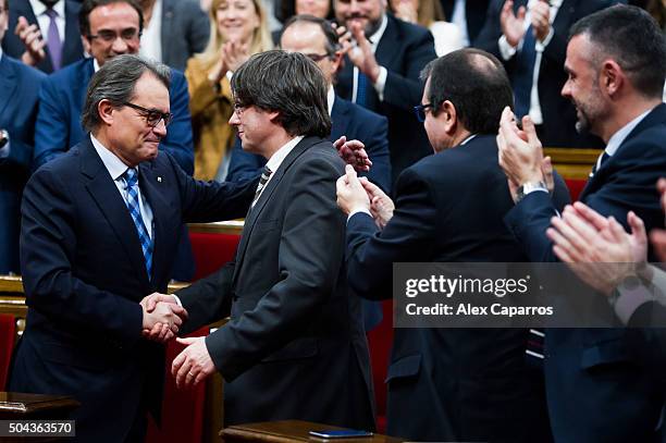Former President of Catalonia Artur Mas congratulates Carles Puigdemont after he was elected new President of Catalonia during the parliamentary...
