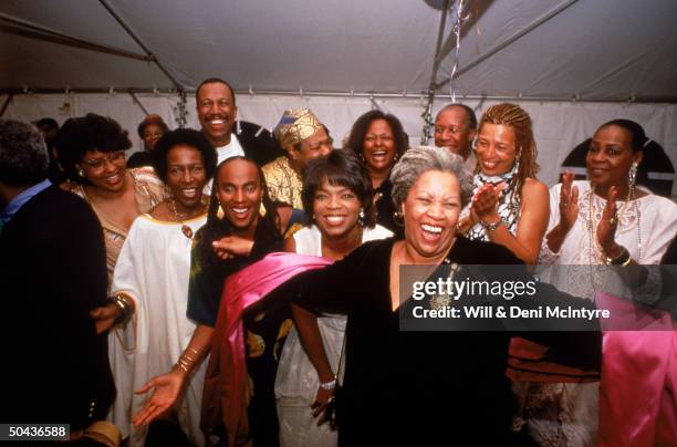 Nobel laureate Toni Morrison accepting the applause of partygoers Susan Taylor, Rita Dove, Oprah Winfrey, Angela Davis, Maya Angelou & others;...