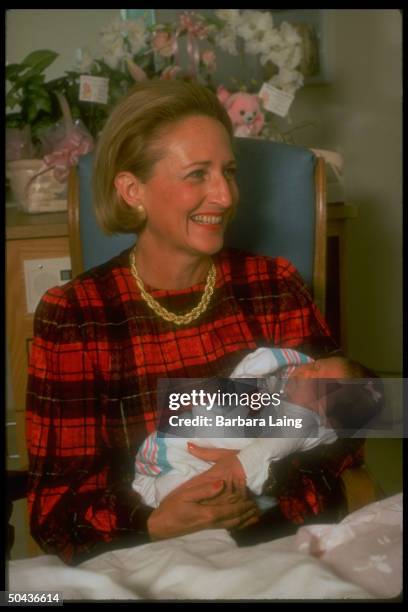 Margot Perot, wife of independent cand. For pres., holding newborn baby during visit to woman's hospital named after her.