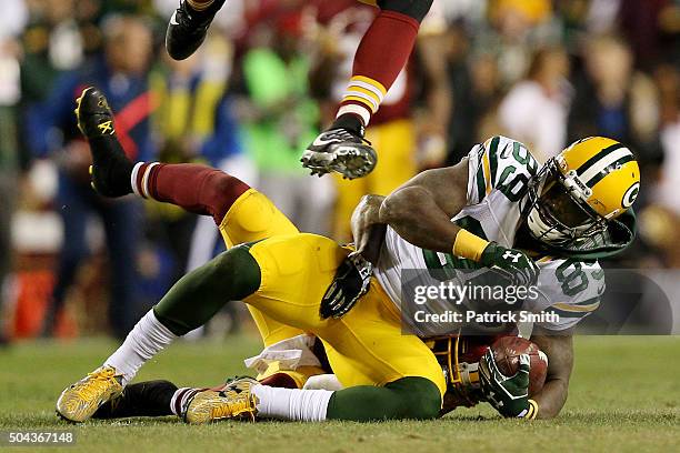 Wide receiver James Jones of the Green Bay Packers is tackled by cornerback Will Blackmon of the Washington Redskins in the second quarter during the...