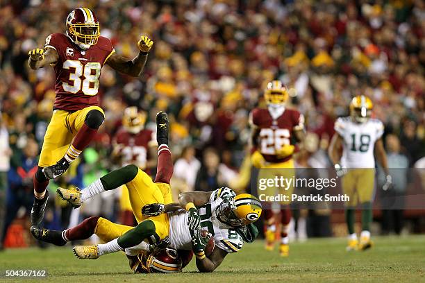 Wide receiver James Jones of the Green Bay Packers is tackled by cornerback Will Blackmon of the Washington Redskins while free safety Dashon Goldson...