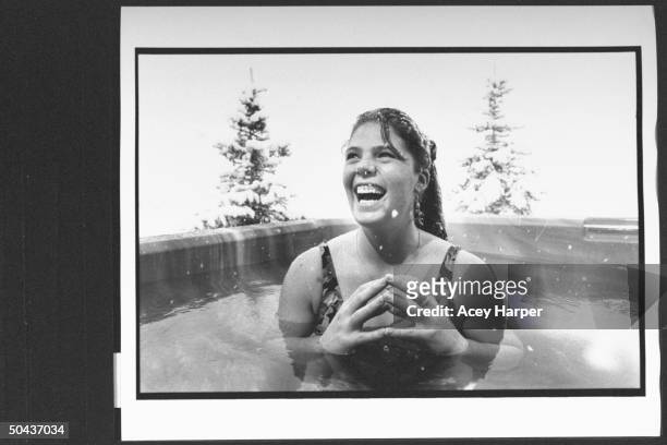 Olympic skier Picabo Street swimsuit-clad as she jubilantly soaks in a turbulent hot tub outside surrounded by snow at a friend's home.