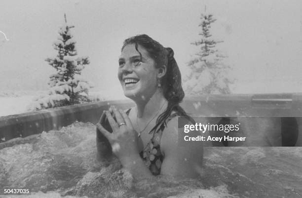 Olympic skier Picabo Street swimsuit-clad as she jubilantly soaks in a turbulent hot tub outside surrounded by snow at a friend's home.