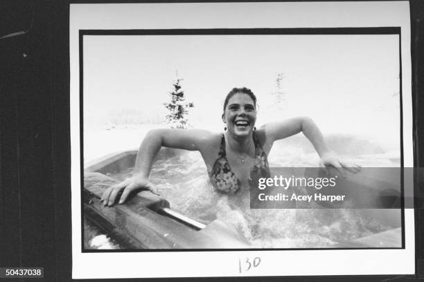 Olympic skier Picabo Street swimsuit-clad as she jubilantly soaks in a turbulent hot tub outside surrounded by snow at a friend's home.