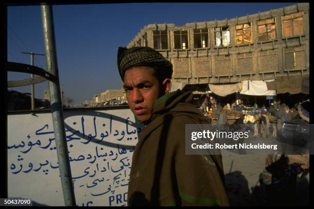 Youth poised on street in city under control of Taliban, faction led by radical Islamic clerics winning civil war.