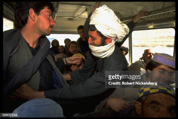 Taliban fighter searching bus passenger for arms @ checkpoint on road to radical Islamic civil war faction's Charasiab HQ .