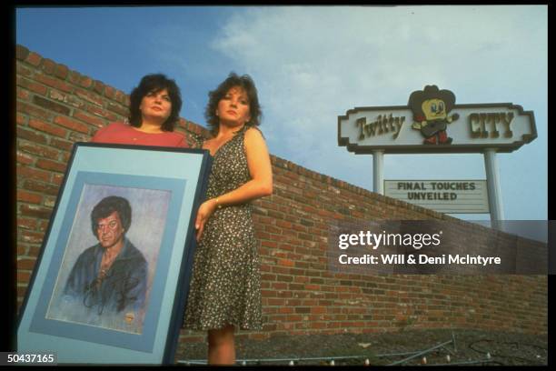 Singer Conway Twitty's daughters Kathy & Joni holding etching of their dad as they stand outside Twitty City music-and-museum complex.