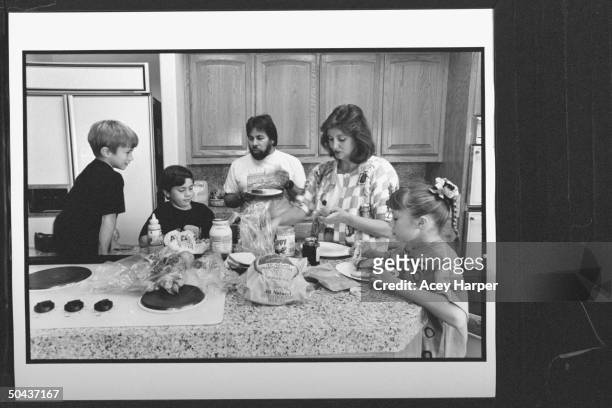 Apple Computer cofounder Steve Wozniak w. His lawyer wife Suzanne Mulkern gathered around kitchen counter w. His kids Gary Jesse & Sarah busy making...