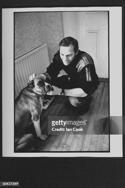 Would-be screenwriter Douglas Gresham, son of Amer. Poet Joy Gresham & executor of his stepdad C.S. Lewis's estate, petting his boxer dog at home.