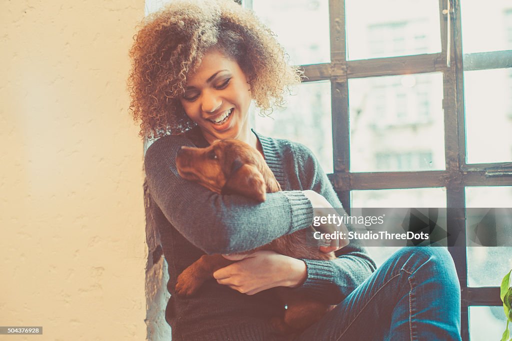 Atraente jovem mulher jogando com filhote africano