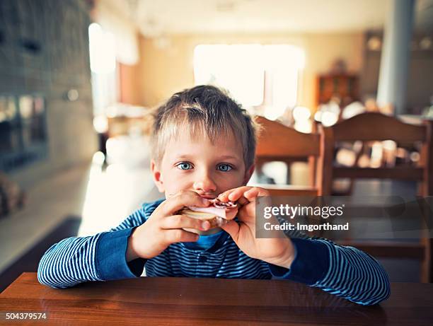 cute little boy eating breakfast - sandwich bildbanksfoton och bilder