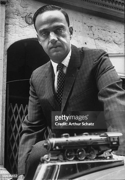 Lawyer Roy Cohn with Lionel locomotive model, which serves as hood ornament of his 1961 Chevrolet Impala convertible, his second office.