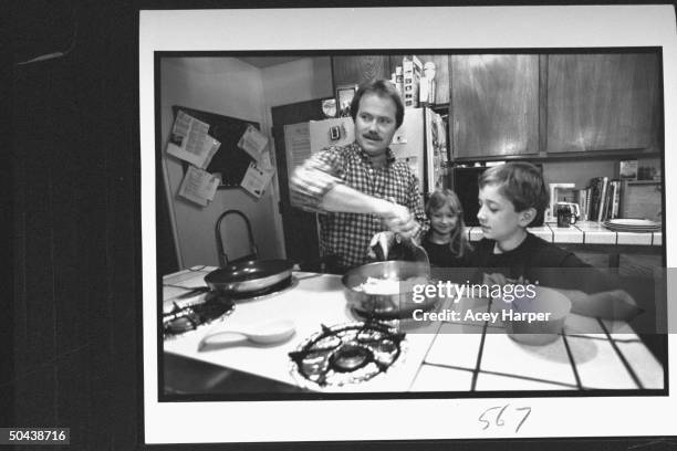 Former child actor Jon Provost, stirring eggs in frying pan for daughter Katie & son Ryan, in kitchen at home.
