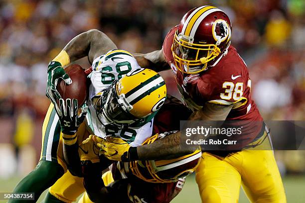 Wide receiver James Jones of the Green Bay Packers is tackled by free safety Dashon Goldson of the Washington Redskins in the second quarter during...