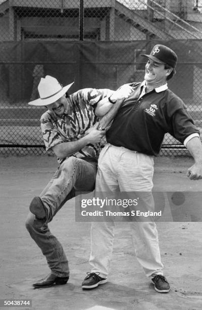 Musician Tim McGraw w. Father, former baseball player Tug McGraw, as they horse around on baseball field.