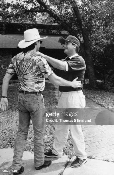 Musician Tim McGraw about to hug father, former baseball player Tug McGraw, as they greet each other outside his home.