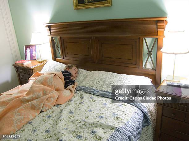 child sleeping on grandparents' bed - bedside table kid asleep stock pictures, royalty-free photos & images